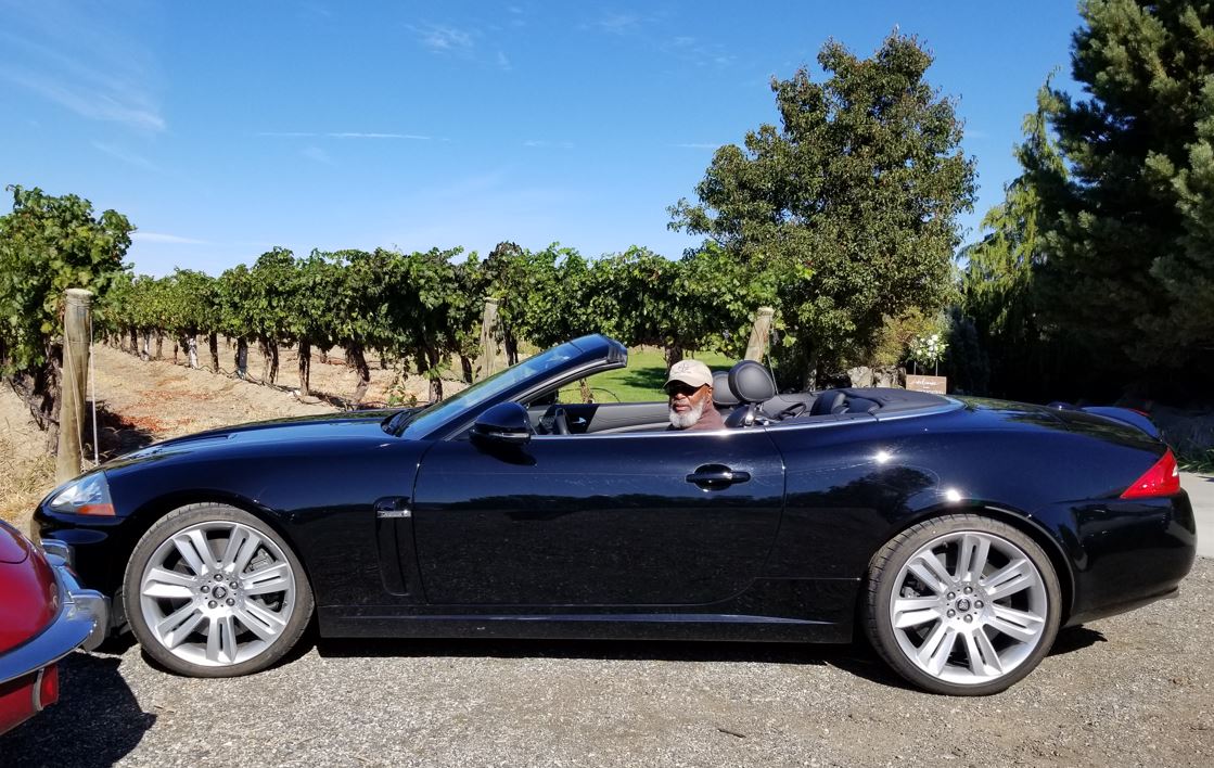 Curt Kyle and his 2011 XKR convertible in front of the vineyard.