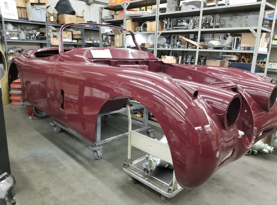 Beautifully restored XK150 body on a support jig